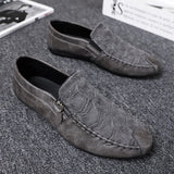 Black textured leather slip-on loafers with zipper for men displayed against a neutral background, showcasing the leather's natural pattern and fashion-forward design.