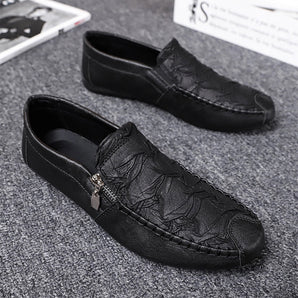 Black textured leather slip-on loafers with a zipper for men, featuring a stylish and sleek design with a smooth finish.