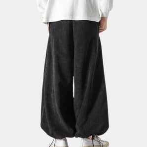 Black unisex wide-leg palazzo trousers with a high waist, featuring a modern design suitable for both formal and casual settings.