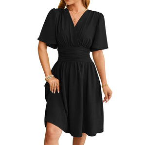 A woman wearing a black V-neck knee-length casual summer dress with pockets, showcasing the dress's sleeveless design and relaxed fit.