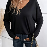 A black V-neck long sleeve blouse, suitable for casual wear, shown in a women's 2XL size. The top is lightweight and features a classic design, paired with jeans to highlight its versatile fashion appeal.