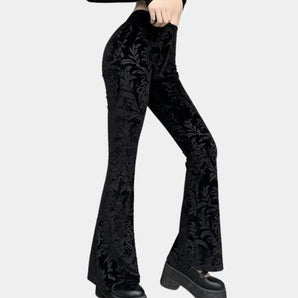 Black velvet high waist bell bottom pants with intricate floral embroidery detailing.