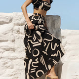 Off-shoulder two-piece dress with abstract black and white pattern, featuring a flowing palazzo pant and complementing top, worn by a model with black hair, highlighting fashion design elements.