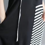 Black and white asymmetric stripe midi dress with a loose fit, featuring short sleeves and a round neck. The dress falls below the knee and has a relaxed, comfortable silhouette.