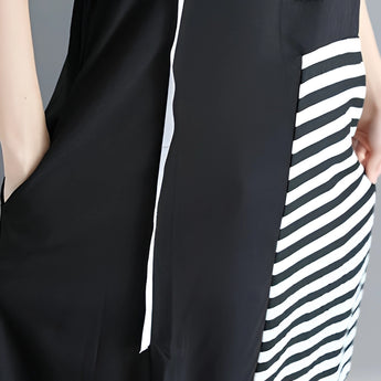 Black and white asymmetric stripe midi dress with a loose fit, featuring short sleeves and a round neck. The dress falls below the knee and has a relaxed, comfortable silhouette.