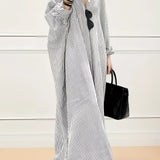 
A long sleeve maxi dress with black and white stripes, featuring a light gray tone. The dress is styled for breezy beachwear, showcasing a relaxed, flowing design with emphasis on shoulder and waist elements.