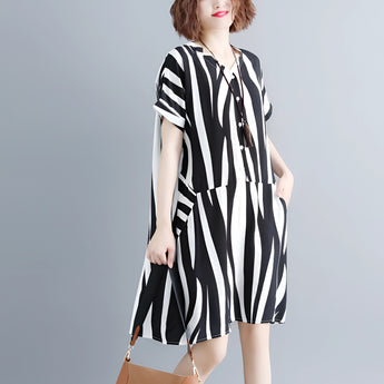 Black and white striped midi dress with short sleeves and button front, worn by a person showing their arm and shoulder.