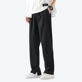 Black wide-leg trousers styled for a minimalist urban look, worn by a person in a casual stance.