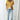 A plus-size yellow double-breasted military jacket with silver buttons, featuring a stylish autumn design, modeled by a woman.