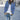 Black women's double-breasted military jacket with silver buttons, styled for autumn fashion, shown in sky blue color, size 5XL. Model pairs it with jeans and a white dress shirt.