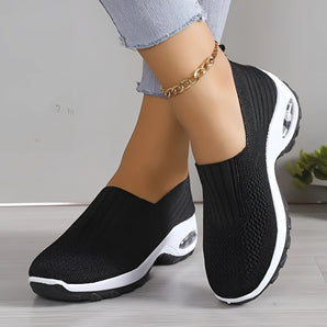 Black women's lightweight breathable slip-on sneakers with a focus on comfort and ease of wear, displayed in a minimalist setting.