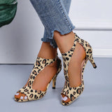 Black women's slingback stiletto peep-toe heels in a leopard print design, featuring a formal sandal style with a high heel. The image focuses on the elegant and stylish footwear, suitable for dressy occasions.