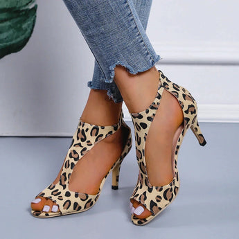 Black women's slingback stiletto peep-toe heels in a leopard print design, featuring a formal sandal style with a high heel. The image focuses on the elegant and stylish footwear, suitable for dressy occasions.