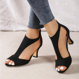 
A pair of black women's slingback stiletto peep-toe heels, styled for formal occasions. The image captures the sleek design of the heel, showcasing the elegant peep-toe front and the slender stiletto heel. The shoe is paired with a knee-length electric blue dress, emphasizing the sophisticated look.