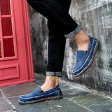 Black woven loafers, breathable and lightweight slip-on shoes displayed standing on a surface, emphasizing their textile material and sleek design.