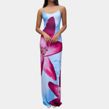 A woman wearing a blue floral maxi dress with spaghetti straps, designed as beachwear for summer. The dress is a 3XL size and features a flowing gown style that reaches the thighs, showcasing a fashionable and elegant look.