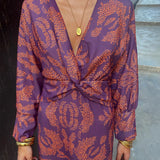 A woman wearing a blue floral midi dress with a V-neck and long sleeves, ideal for fall fashion and evening wear.
