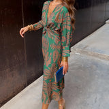 Woman wearing a green V-neck long sleeve floral midi dress, suitable for fall fashion and evening events, size 3XL.