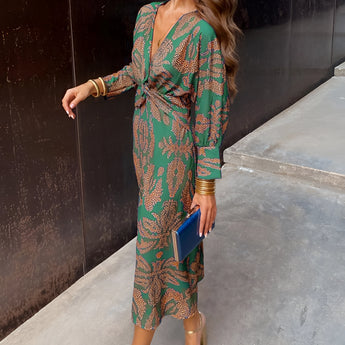 Woman wearing a green V-neck long sleeve floral midi dress, suitable for fall fashion and evening events, size 3XL.