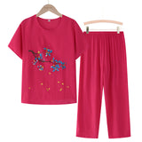 A red 4XL women's casual summer pants set featuring a blue linen top with floral embroidery, long sleeves, and a round neckline.