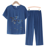 A blue linen top with floral embroidery on the blouse, featuring short sleeves and a casual summer design, displayed on a clothes hanger.