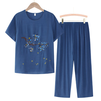 A blue linen top with floral embroidery on the blouse, featuring short sleeves and a casual summer design, displayed on a clothes hanger.
