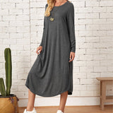 
A woman wearing a dark gray, long sleeve, knee-length casual dress.