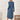 
A woman wearing a blue long sleeve casual knee-length dress designed for comfort, featuring a sheath silhouette with a focus on the arms, shoulders, and neck for a relaxed fit.