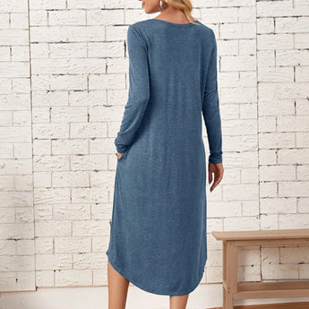 
A woman wearing a blue long sleeve casual knee-length dress designed for comfort, featuring a sheath silhouette with a focus on the arms, shoulders, and neck for a relaxed fit.