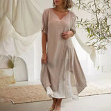 
A woman wearing a khaki 3XL blue ombre asymmetric tunic dress with a draped neckline, featuring short sleeves and a midi length.