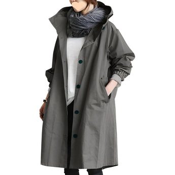 A woman wearing a dark gray oversized waterproof hooded raincoat in size 4XL, showcasing the breathable and stylish design with long sleeves and a high collar.