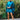 Blue satin mini dress featuring draped cape sleeves, styled for luxury women's cocktail wear. The dress highlights shoulder and neck details, capturing an elegant fashion statement.