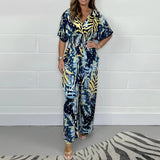 A blue tropical leaf print maxi dress with an elegant V-neck design, featuring short sleeves and a fitted waist, perfect for summer fashion.