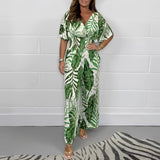 Elegant V-neck summer maxi dress featuring a blue tropical leaf print pattern on a light green fabric, designed with sleeves and a fitted waist, suitable for formal and casual occasions.