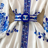 Blue and white porcelain print long sleeve floral dress with belt featuring a collared neckline and intricate pattern.