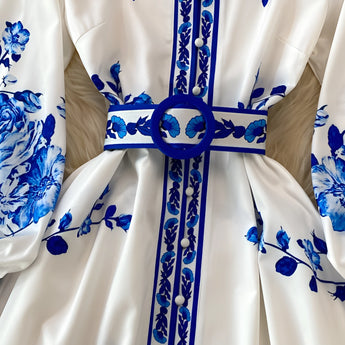 Blue and white porcelain print long sleeve floral dress with belt featuring a collared neckline and intricate pattern.