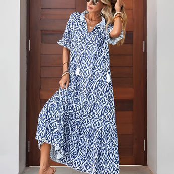 Woman wearing a blue and white V-neck boho maxi dress, perfect for lightweight summer beachwear, standing outdoors with sunglasses.