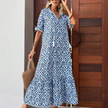 Woman wearing a blue and white V-neck boho maxi dress ideal for lightweight summer beachwear, paired with sunglasses.