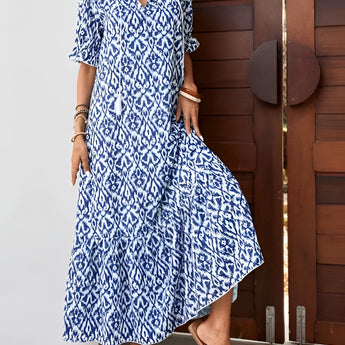 Fashion model wearing a blue and white V-neck boho maxi dress with short sleeves, showcasing the lightweight summer beachwear.