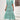 A woman wearing a blue and white V-neck boho maxi dress with short sleeves, designed as lightweight summer beachwear in a mint blue color and XL size.