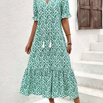 A woman wearing a blue and white V-neck boho maxi dress with short sleeves, designed as lightweight summer beachwear in a mint blue color and XL size.