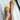 Blush pink low heel ballet flats on a woman's feet, displayed against a wooden background.
