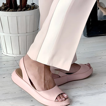 Blush pink low heel ballet flats for women on a white and black background, emphasizing comfort and minimalist design.