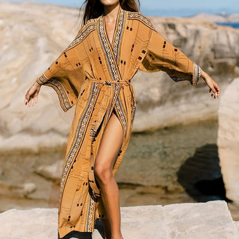 A woman wearing a Bohemian beige kimono with a boho-chic tribal pattern, standing outdoors in a desert setting.