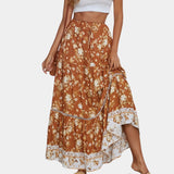 
A woman wearing a Bohemian blue floral maxi skirt paired with an orange top, showcasing a lightweight summer beachwear outfit. The skirt features a flowing, one-piece design suitable for XL size, ideal for casual daytime outings.