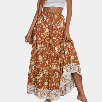 
A woman wearing a Bohemian blue floral maxi skirt paired with an orange top, showcasing a lightweight summer beachwear outfit. The skirt features a flowing, one-piece design suitable for XL size, ideal for casual daytime outings.