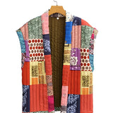 Bohemian embroidered patchwork dress with a creative artisan design, featuring magenta and other vibrant colors. The dress is displayed on a clothes hanger, showcasing its unique sleeve and collar design, reminiscent of summer fashion outerwear.