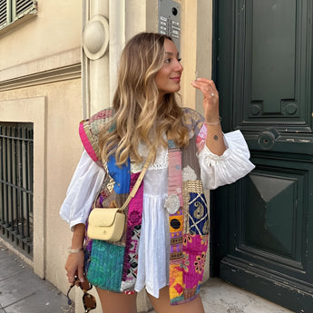 Bohemian embroidered patchwork dress showcasing intricate artisan design, featuring colorful patterns and a flowing summer style, worn by a model accessorized with sunglasses.
