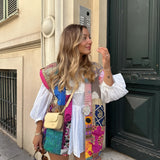 
A bohemian embroidered patchwork dress featuring a vibrant design with intricate detailing, showcasing elements like sleeves, neck, and waist. The dress has a summery fashion style with a cool pink hue, perfect for an artistic and chic look.