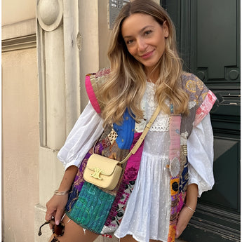 Bohemian embroidered patchwork dress featuring intricate designs, showcased on a model smiling with visible shoulders and neck, highlighting the dress's pink tones and fashion-forward collar and sleeves, perfect for summer artisan fashion.